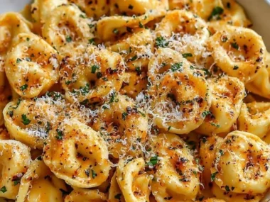 Plate of easy garlic herb parmesan tortellini topped with fresh herbs