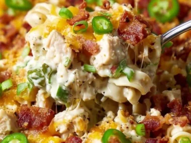 Delicious Jalapeño Popper Chicken Casserole topped with cheese and jalapeños