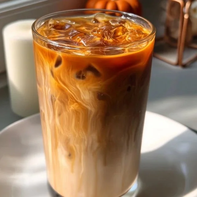 Iced Caramel Macchiato with caramel drizzle and milk in a glass