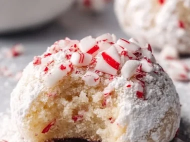Delicious Peppermint Snowball Cookies dusted with powdered sugar on a festive plate.