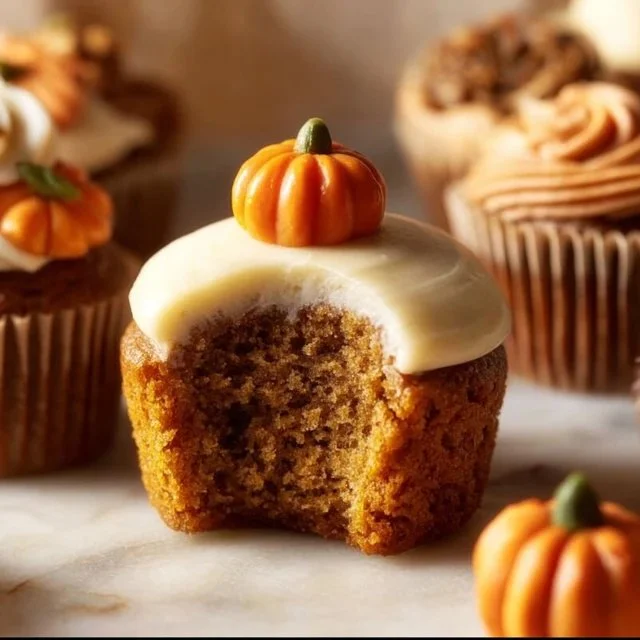 Delicious pumpkin cupcakes with brown sugar cream cheese frosting on a white plate