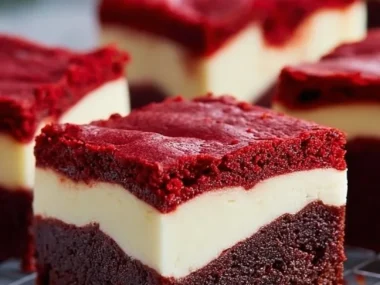 Plate of red velvet cheesecake brownies with creamy topping