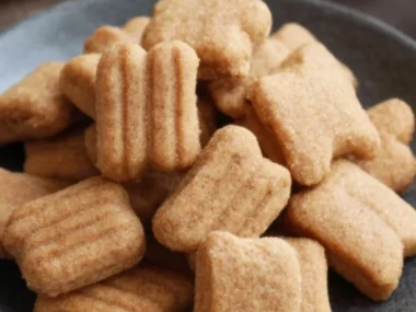 Homemade apple and banana dog treats on a wooden surface