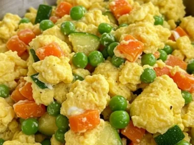 A bowl of Veggie Egg Scramble for Dogs filled with fresh vegetables and eggs.