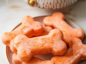 Homemade frozen carrot treats for dogs in a colorful bowl