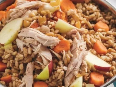 A bowl of Chicken and Apple Dog Food, featuring chunks of chicken and apple slices.