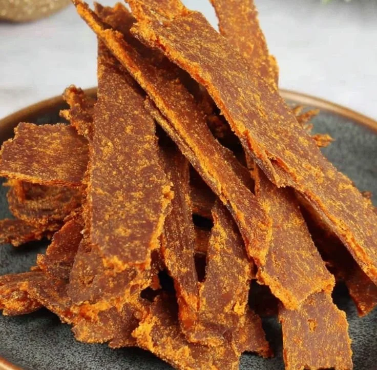 Homemade dehydrator pumpkin leather dog treats on a wooden kitchen table