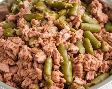 A bowl of lean turkey and green beans, a healthy meal option for dogs.
