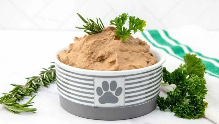 Homemade liver pâté for dogs in a bowl with dog treat biscuits