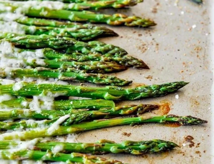Plate of roasted Parmesan asparagus with a golden crispy topping.