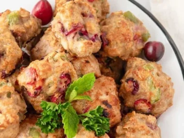 Homemade turkey meatballs for dogs in a bowl with fresh herbs.