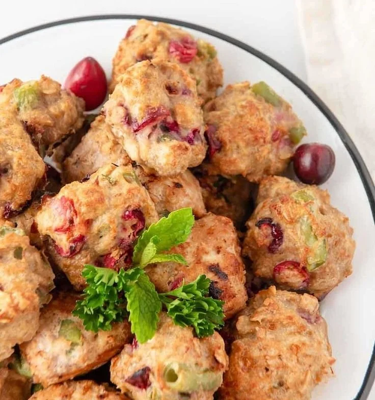 Homemade turkey meatballs for dogs in a bowl with fresh herbs.
